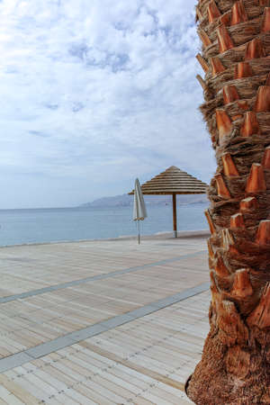 Beautiful public sandy beaches on Red Sea in Eilat with stro umbrellas, luxury vacation spa resorts...