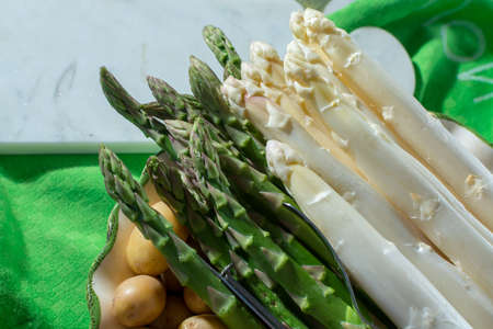 Raw uncooked high quality white and green asparagus, ready to cook for dinner, seasonal dishの写真素材