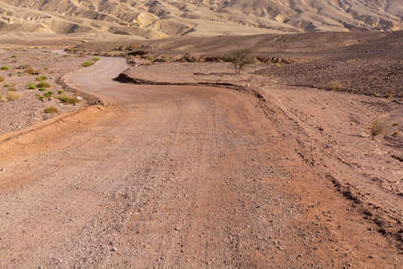 Dirt road in desert Negev, Israel,  transport infrastructure in desert, scenic mountains route from Eilat to north of Israelの写真素材