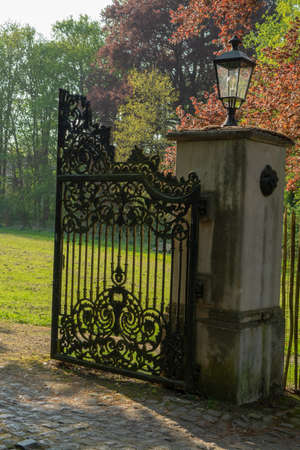 Open iron vintage entrance gates in old castle, sunny dayの写真素材