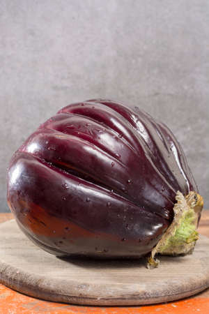 Israeli Huge Baladi Big ripe whole raw violet eggplant on table close up
