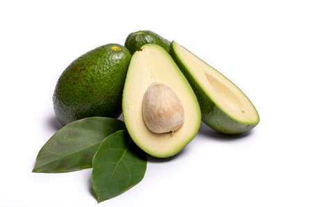 Fresh organic ripe green whole and sliced Fuerte avocado with leaves, copy space close up isolated on white backgroundの写真素材