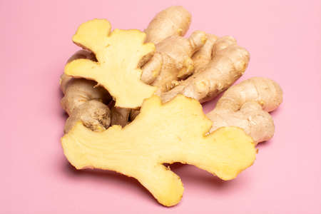Trendy food flat lay concept on light pink background with fresh big ginger root close up copy space...