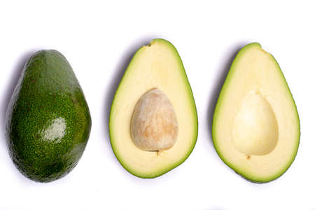 Fresh organic ripe green whole and sliced Fuerte avocado with leaves, copy space close up isolated...