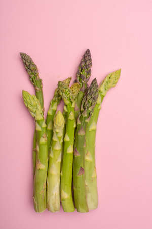 Delicious bunch of raw ripe green asparagus new harvest isolated on trendy pink background flat lay food conceptの写真素材