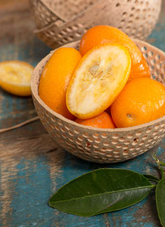 Delicious small citrus fruits orange kumquats close up on wooden table