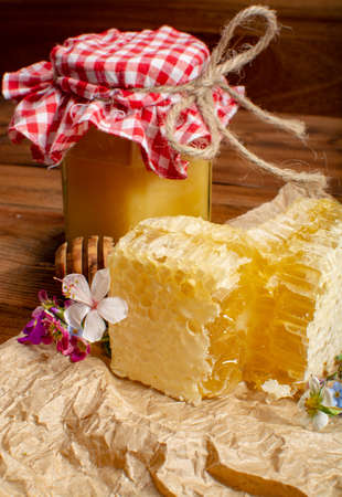 Homemade organic honey in honeycomb from farm apiary on mountains meadows with summer wild flowersの写真素材