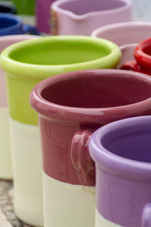 Rows with colorful glazed ceramic jars, flower pots, vases for saleの写真素材