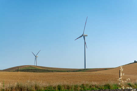 Modern wind farm with big wind turbines towers, source for renewable green energy