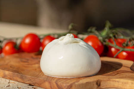 Fresh soft white burrata, buttery cheese, made from a mix of mozzarella and cream, original from Apulia region, Italy with tomatoesの写真素材