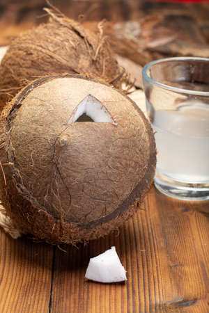 Big tropical palm nut coconut and coconut milk on wooden background close upの写真素材