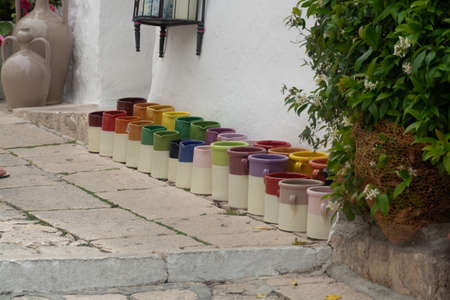 Rows with colorful glazed ceramic jars, flower pots, vases for saleの写真素材
