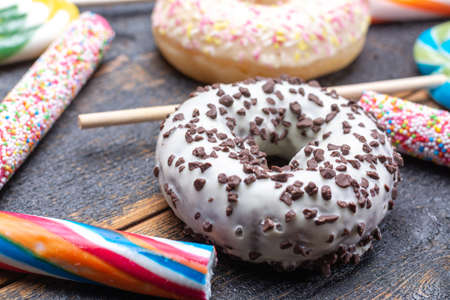 Children party background with sweet colorful donuts and candy close up on wooden tableの写真素材