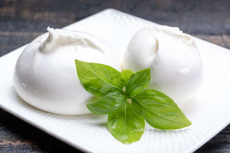 Fresh soft white burrata, ball buttery cheese, made from a mix of mozzarella and ricotta cream, original from Apulia region, Italy, very popular soft cheese in USAの写真素材