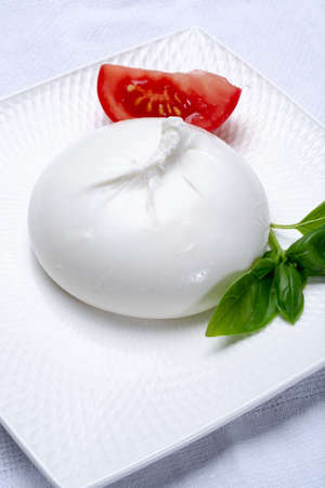 Fresh soft white burrata, ball buttery cheese, made from a mix of mozzarella and ricotta cream, original from Apulia region, Italy, very popular soft cheese in USAの写真素材