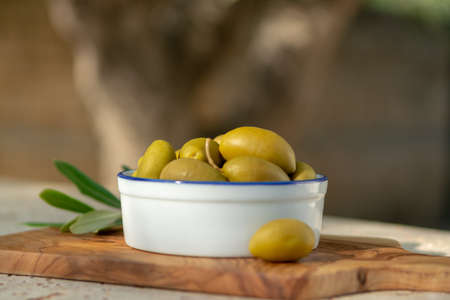 Bowl with green olives served as snack outdoor in olive tree gardenの写真素材