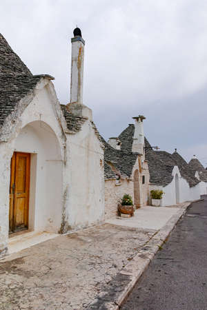 Unique small South Italia city Alberobello with antient stones conical houses trullo, tourist destination, Apulia region near Bariの写真素材