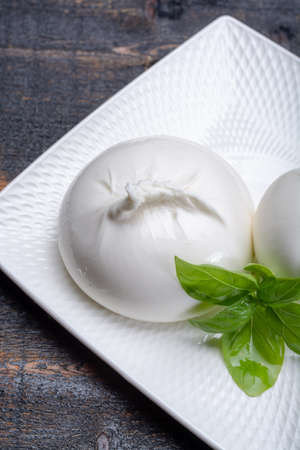 Fresh soft white burrata, ball buttery cheese, made from a mix of mozzarella and ricotta cream, original from Apulia region, Italy, very popular soft cheese in USAの写真素材