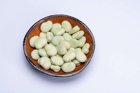 New harvest of healthy vegetables, green fresh raw big broad beans close up isolated on white...