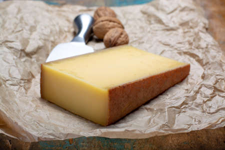 Piece of aged Comte or Gruyere de Comte, AOC French cheese made from unpasteurized cow's milk in the Franche-Comte region of eastern France with traditional methods of production close up.の写真素材