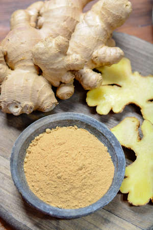 Fresh raw ginger roots from China  and bowl with ginger powder close upの写真素材
