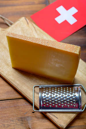 Block of Swiss hard cheese Le Gruyere used for traditional fondue and gratin, close-up