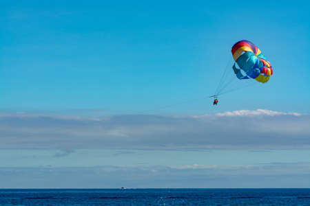 Sea and beach sport for tourists, parasailing in blue sky copy space