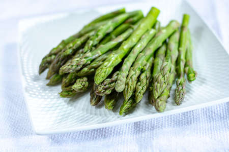 Fresh raw green asparagus vegetable on white board close upの写真素材