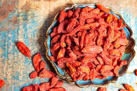 Healthy superfood, red dried goji chinese wolfberry berries, used in many snack foods and supplements, granola bars, yogurt, tea blends, fruit juice as whole berries or ground seeds, seed oil close up.の写真素材