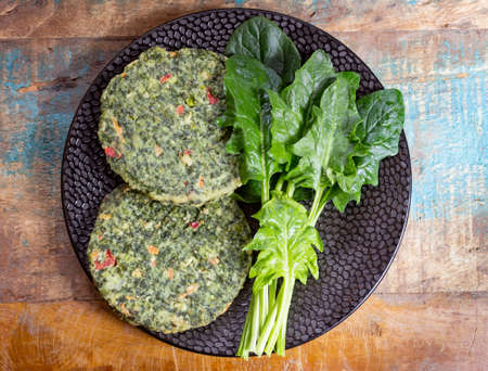 Healthy vegetarian or vegan food, uncooked green spinach burgers, ingredient for hamburgers close up