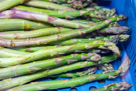 Ripe organic green asparagus on farmers market in blue box ready to cookの写真素材