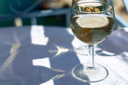 White wine served outside on balcony on glass table with sea view close upの写真素材