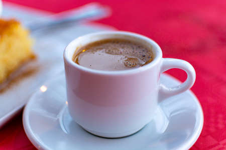 Traditional greek coffee served in white coffee set in cafe close upの写真素材