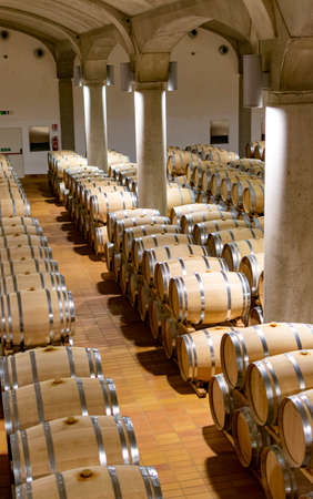 Big dark wine cellar with old oak barrels, production of red dry or sweet wine in Marsala, Sicily,...