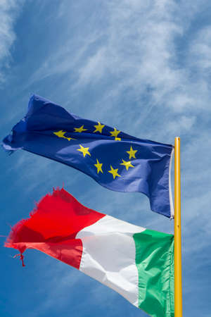 Two colorful flags of Italy and European Union fluttering in the wind