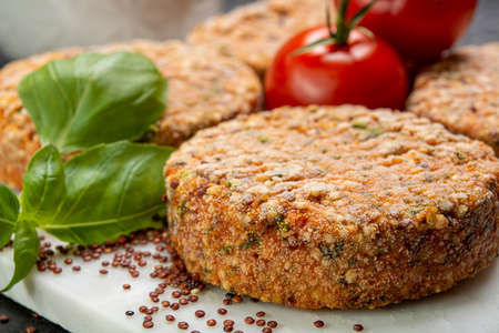 Tasty vegetarian burgers made from healthy quinoa, basil, tomatoes and mozzarella cheese close up