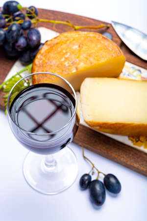 Hard Italian pecorino sheep cheese and glass with Italian red wine close up on white backgroundの写真素材