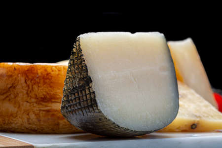 Cheese collection, Variety of Italian pecorino cheeses, aged with black peppers from Nebrodi, white Il Palio and black molarotto, close upの写真素材