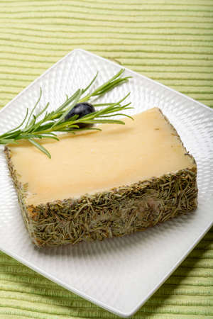 Cheese collection, one piece of Spanish manchego sheeps milk cheese with rosemary herbの写真素材