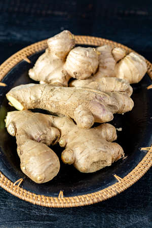 Fresh ginger roots close up on black wooden background, asian food conceptの写真素材
