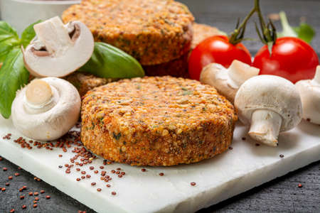 Tasty vegetarian burgers made from healthy quinoa, basil, tomatoes and champignon mushrooms close upの写真素材