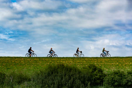 Four people riding on bicycles in sunny day in Netherlands, sport conceptの写真素材