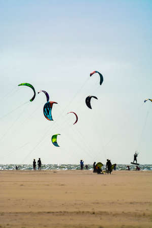 Water sport event, colorful kite surfers race in North Sea near Renesse, Zeeland, Netherlands