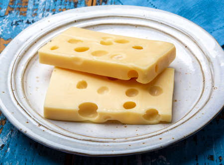 Two blocks of French emmental semi-hard cheese close up