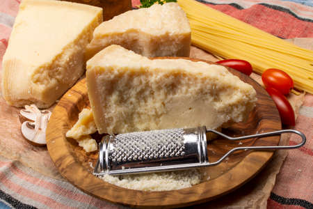 Cooking with hard italian cheese, grated parmesan or grana padano cheese close up