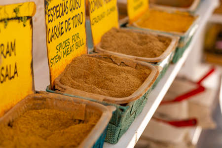 Dried kitchen herbs and different spices in boxes for sale in shop in Andalusia, Spain, close up