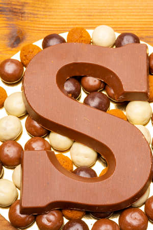 Celebration of Saint Nicholas, patron saint of children in Netherlands, Belgium, Luxembourg and North of France in first week of December, chocolate letters S and ginger cookies close upの写真素材