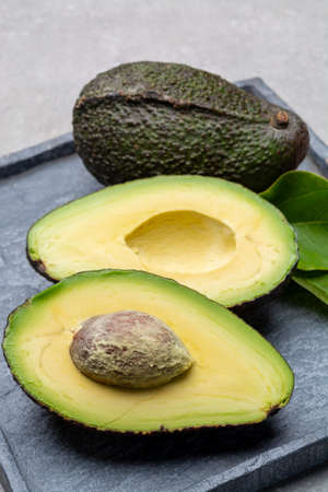 New harvest of fresh ripe hass avocado close cut in half with seed