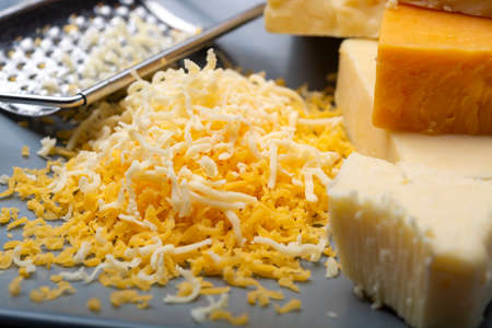 Cheese collection, matured and orange original British cheddar cheese in blocks and grated served on...