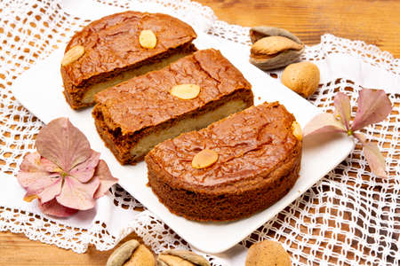 Fresh baked Dutch filled spicy cookies with almonds in autumn colors on dark wooden background close upの写真素材